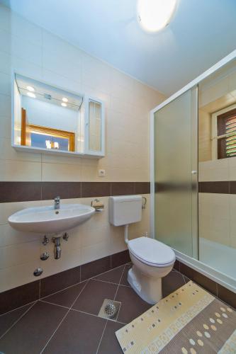 a bathroom with a toilet and a sink and a mirror at Guest House Katica in Zaton
