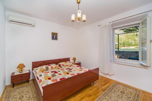 a bedroom with a bed and a window at Guest House Katica in Zaton