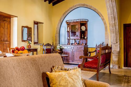 a living room with a couch and an archway at To Konatzi tou Flokka in Ayios Theodhoros