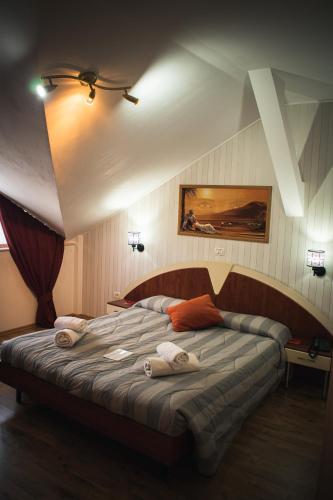 ein Schlafzimmer mit einem Bett, auf dem Handtücher liegen in der Unterkunft Hotel vila veneto in Timişoara