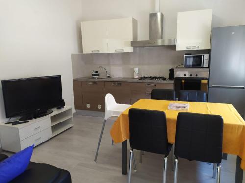 een keuken met een tafel met stoelen en een televisie bij Appartamenti con 1 e 2 camere Caldiero in Caldiero