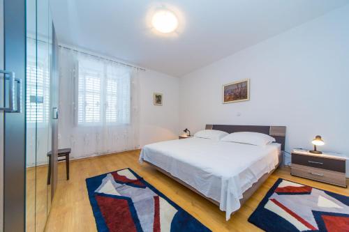 Dormitorio blanco con cama y pared de cristal en Guest House Katica en Zaton