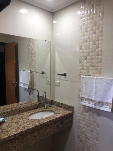 un baño con lavabo y espejo en Studio Julio Cezar, en Foz do Iguaçu