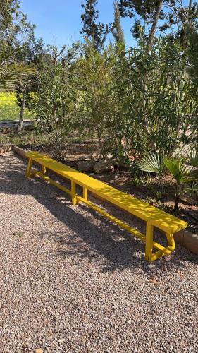 a yellow bench sitting on the ground in a park at Agroturismo S Hort de Can Carrio AG226 in Ses Salines