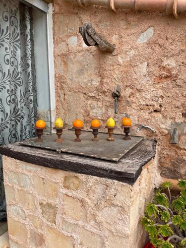 a stone wall with orange spheres on a ledge at Agroturismo S Hort de Can Carrio AG226 in Ses Salines