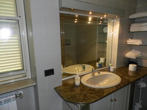 baño con 2 lavabos y espejo grande en Pit Stop, en Campagnano di Roma