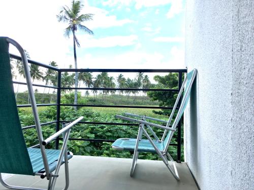 a balcony with a chair and a palm tree at Pousada Brisa e Mar in Praia do Frances