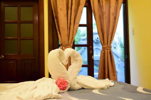 a couple of towels in the shape of a heart on a bed at La casita de Angie in Antigua Guatemala