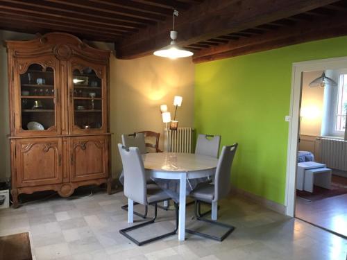 een eetkamer met groene muren en een tafel en stoelen bij L' Huis-au-Tilleul in Quarré-les-Tombes