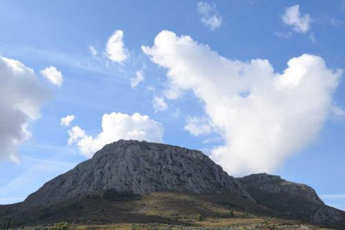a mountain with a cloudy sky in the background at Vasilios Marinos Rooms in Korinthos