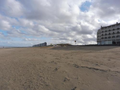 an empty beach with a hotel and a building at Studio On The Beach With Sea View in Middelkerke