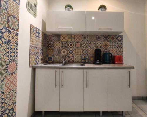 a kitchen with white cabinets and a sink at L'Oriflamme in Avignon