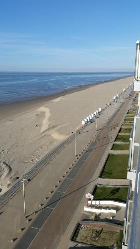 a road next to a beach next to the ocean at Studio On The Beach With Sea View in Middelkerke