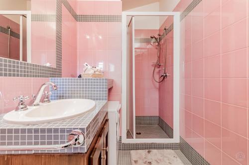 een roze badkamer met een wastafel en een douche bij Il Dolce Rifugio. Piazza principale di Leonessa in Leonessa