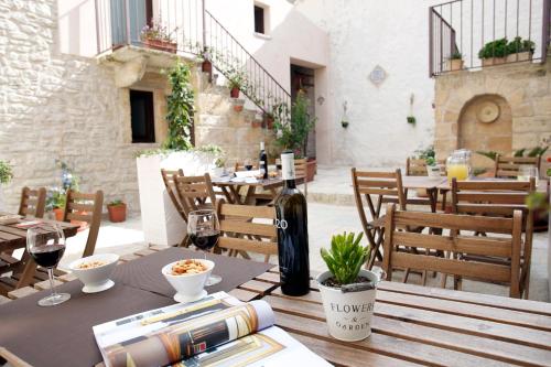 a table with a bottle of wine sitting on a patio at Residence San Martino in Erice