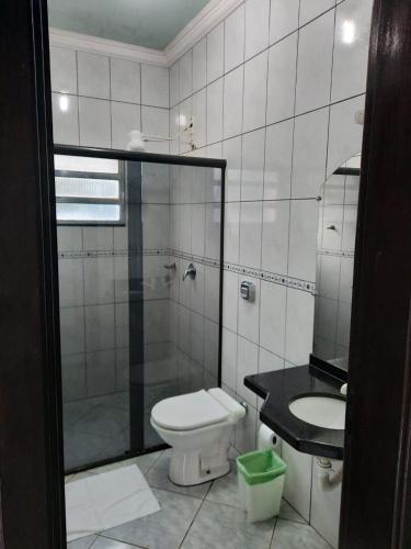 a bathroom with a toilet and a shower and a sink at Bravo City Hotel Nova Mutum in Nova Mutum