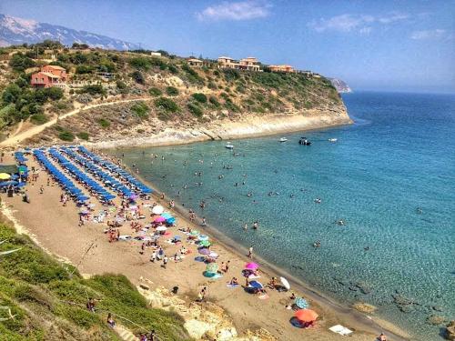 a beach with a bunch of people in the water at Casa De Rosa Apartments & Studios in Svoronata
