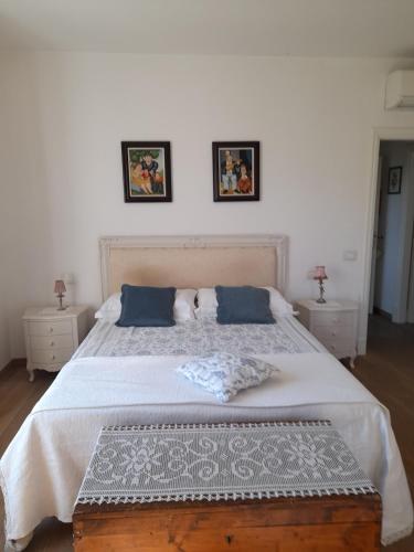 a bedroom with a large white bed with blue pillows at Villa la provenzale in Camaiore