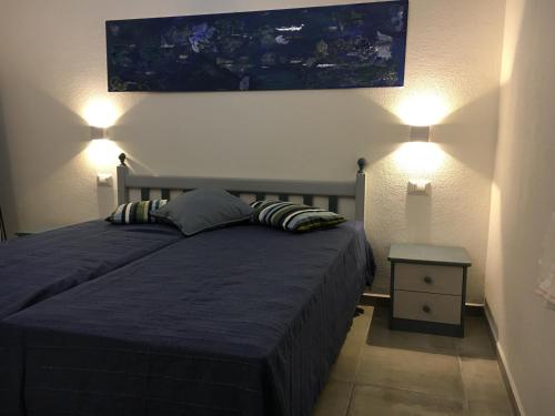 een slaapkamer met een bed met 2 kussens en een schilderij aan de muur bij Sa Tanca de Su Catreathu in Orosei