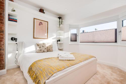 a white bedroom with a bed and a window at Charming 3 Bedroom House garden & parking - next to CS Lewis Nature Reserve in Oxford