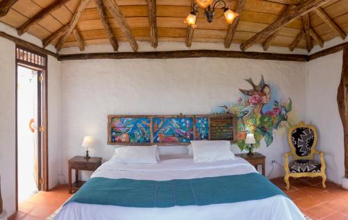 a bedroom with a bed with a painting on the wall at Akawanka Lodge in San Agustín