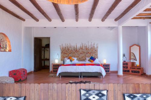 a bedroom with a bed with a wooden headboard at Akawanka Lodge in San Agustín