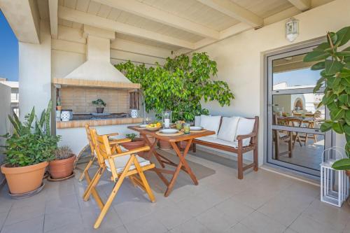 a patio with a table and chairs and a fireplace at Sunny Penthouse,Modern Amenities+Aegean View in Rhodes Town