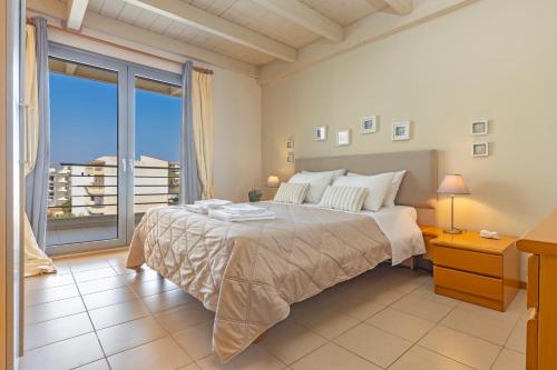 a bedroom with a large bed and a large window at Sunny Penthouse,Modern Amenities+Aegean View in Rhodes Town