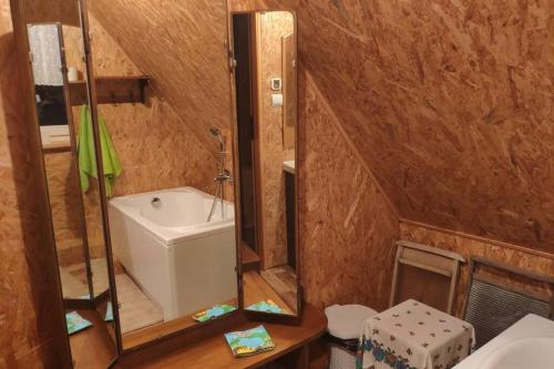 ein Bad mit einem Waschbecken und einem Spiegel in der Unterkunft Drewniany dom nad starorzeczem Narwi in Pianki