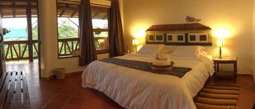 a bedroom with a large bed in a room with windows at Akawanka Lodge in San Agustín