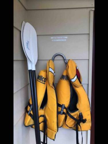 a group of yellow gloves and a paddle on a wall at Te Anau Holiday Home - Free WIFi - Free Bikes & Kayaks - Short Walk to Lake & Town - Top Views in Te Anau