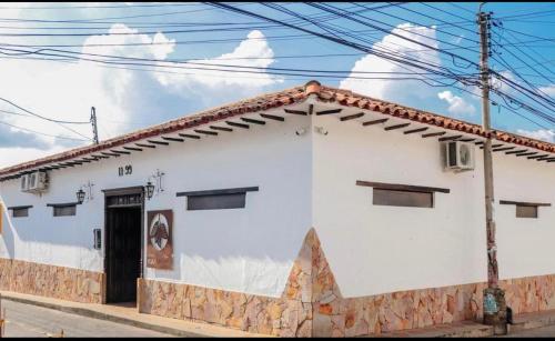 a white building with a black door on a street at Hotel Boutique Casa Grande in Piedecuesta