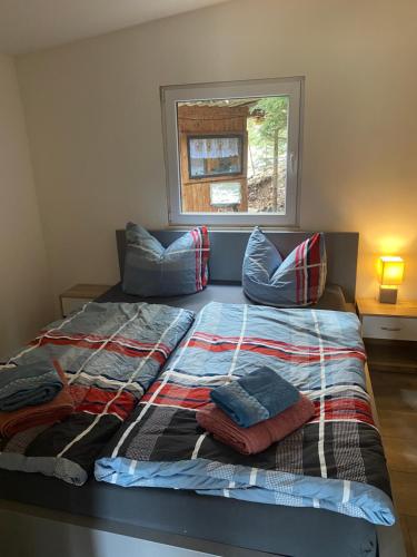 a bed with a blanket and pillows in a bedroom at Glückshütte in Unterwellenborn