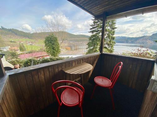 two red chairs and a table on a balcony at Glückshütte in Unterwellenborn
