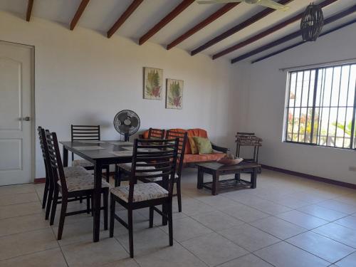 a dining room with a table and chairs and a couch at Maria Jose Bungalows in Zorritos