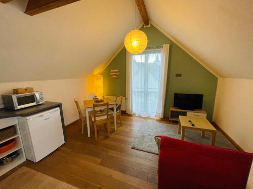 a living room with a kitchen and a table with a microwave at Ferienwohnung „Klein aber fein“ in Urbar