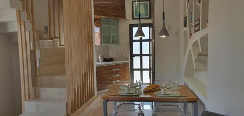 a kitchen with a wooden table with chairs and stairs at Blueonar in Chania