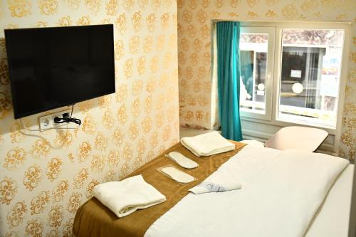 1 dormitorio con 1 cama y TV de pantalla plana en la pared en ada hotel, en Estambul