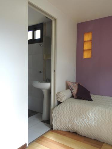 um quarto com uma cama, um lavatório e um espelho em Jardín de Iris em Maipú