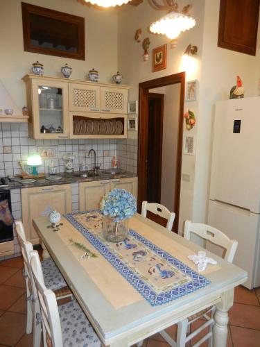 a kitchen with a table and a refrigerator at PietraMilia in Terricciola