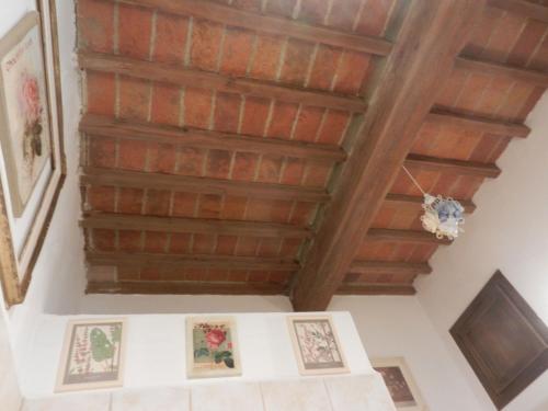 a room with wooden ceilings and pictures on the wall at PietraMilia in Terricciola