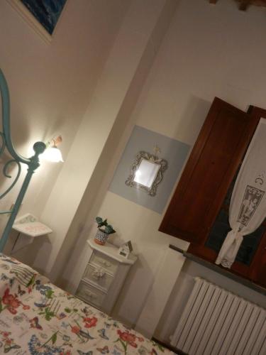a bedroom with a bed and a lamp and a cabinet at PietraMilia in Terricciola