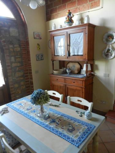 a dining room with a table and a cabinet at PietraMilia in Terricciola
