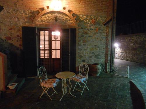 a table and chairs in a room with a brick wall at PietraMilia in Terricciola