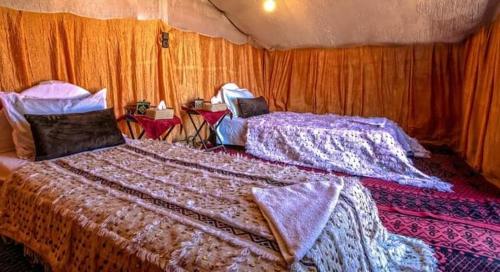 a bedroom with two beds in a tent at Tikida Camp by tinfou in Zagora