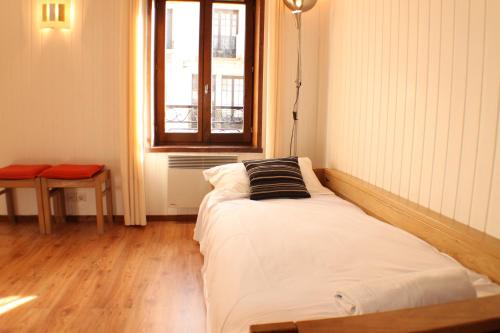 un lit dans une chambre avec une fenêtre dans l'établissement Apartment Relais de Poste Centre Chamonix Mont Blanc, à Chamonix-Mont-Blanc