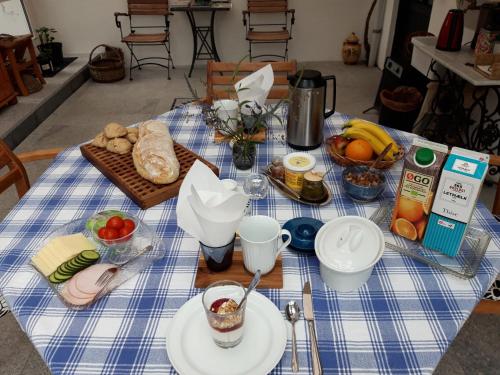 uma mesa com uma toalha de mesa azul e branca com alimentos em Koppes Mølle B&B - naturnær overnatning em Borup