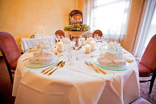 a table with a white table cloth and candles on it at Hotel Krone OHG in Gerlingen