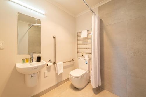 a white bathroom with a toilet and a sink at Alpine Star in Lake Tekapo