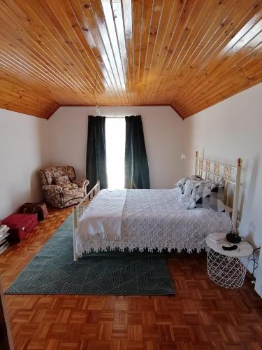 a bedroom with a bed with a wooden ceiling at Giravillage in Girabolhos